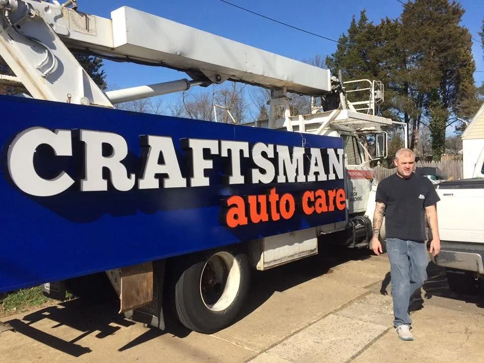 Crane-truck sign installation — Craftsman Auto Care